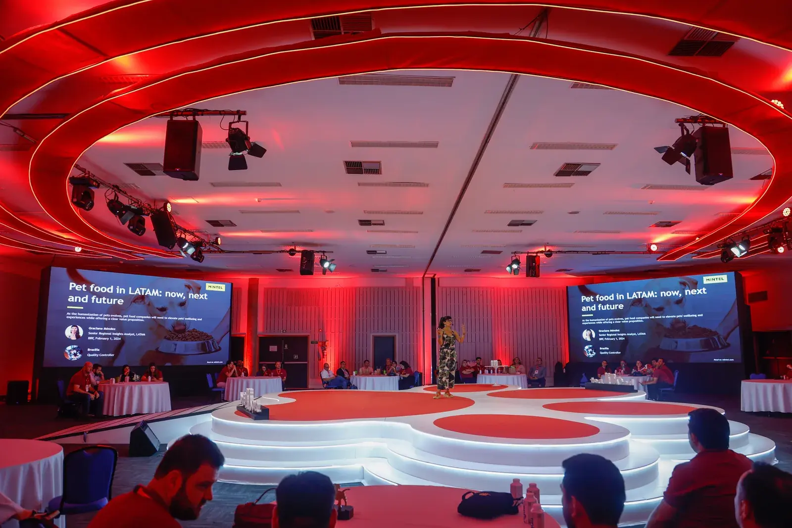 Plenária 360º iluminada em vermelho, com o palco em formato de pata ao centro