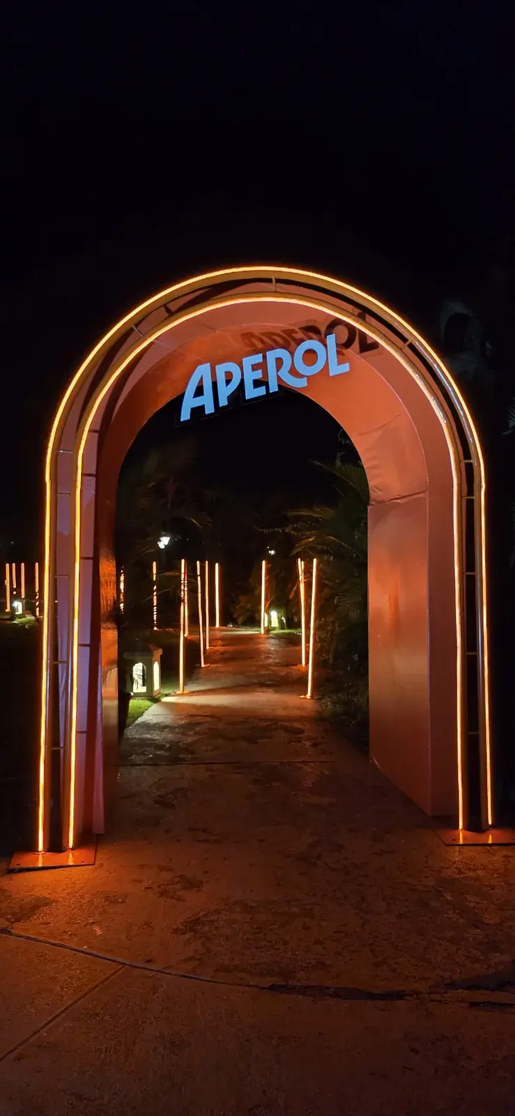Instalação do Aperol em neon sobre uma parede de pedra