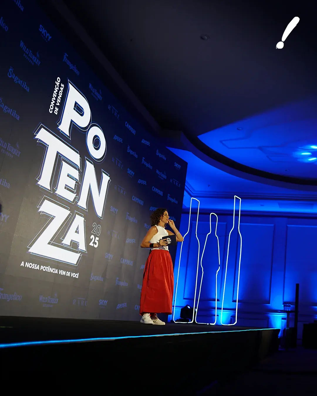 Apresentação no palco diante do painel Potenza 25