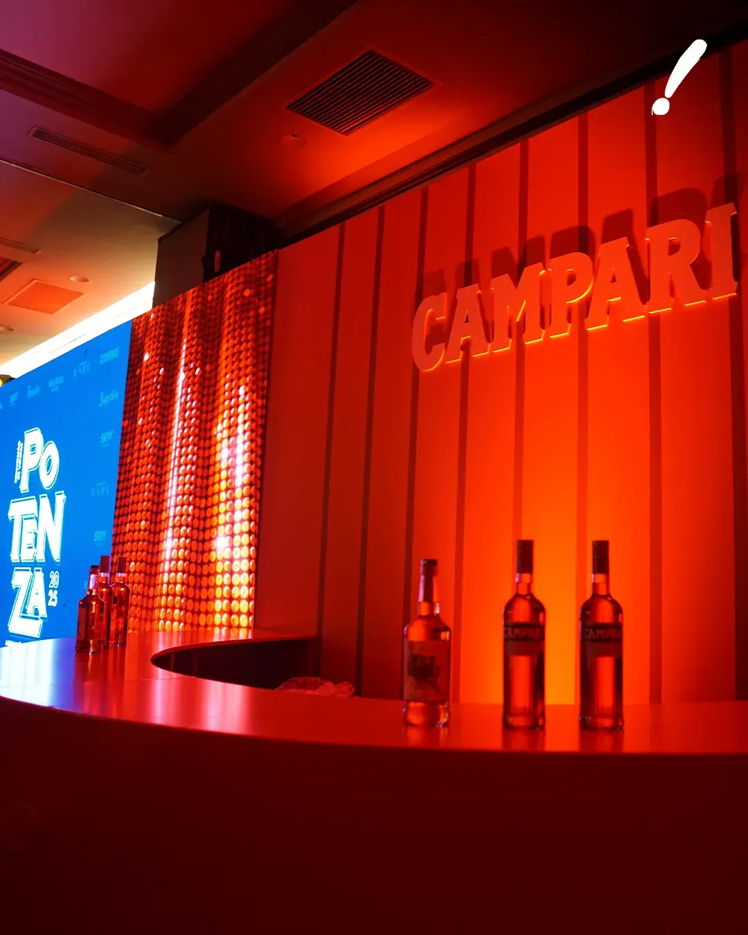 Bar do evento em vermelho Campari, com as garrafas em destaque