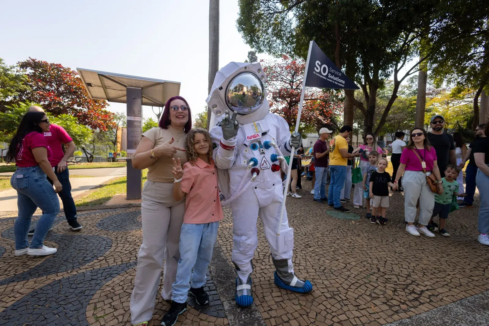 Mother and daughter pose with an actor dressed as an astronaut at one of the activations