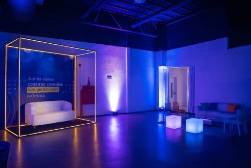 Ambientação com estrutura dourada e mobiliário iluminado