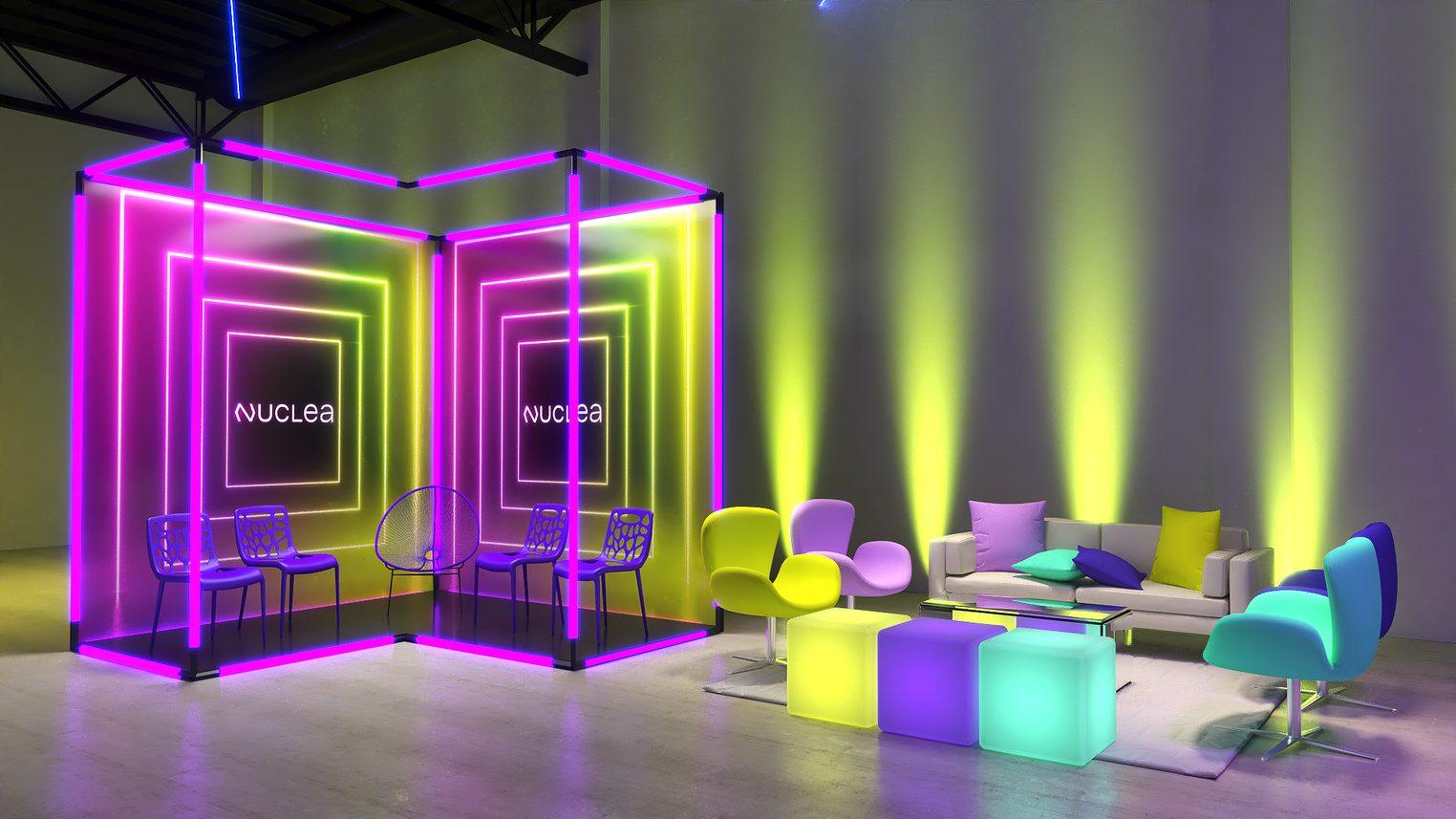 Instalação de neon colorido com pufes na área de convivência