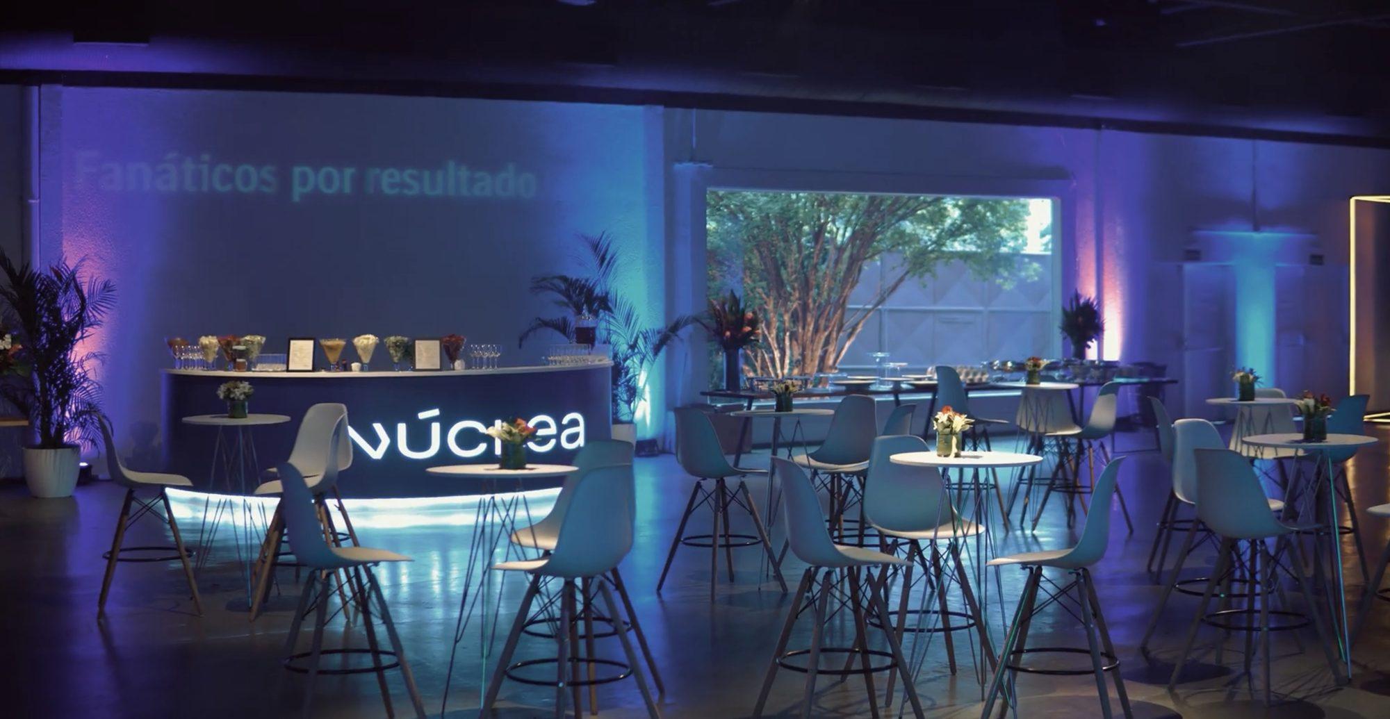 Lounge do evento com o bar iluminado da Núclea